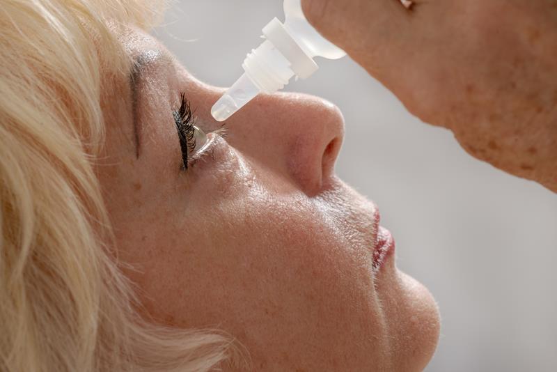 Older person applying dry eye drops